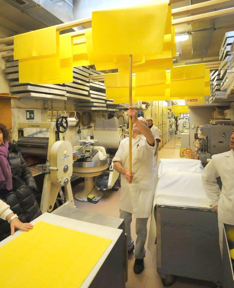 Sfoglie di pasta stese su tralicci del soffitto del negozio. Foto d'archivio storica.